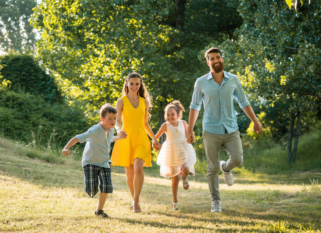Personal Insurance - Active Young Parents With a Healthy Lifestyle Running Together With Their Two Children